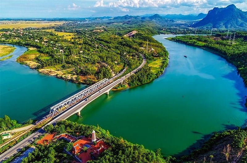 Du lịch Nha Trang tự túc: Hình ảnh một người phụ nữ đang đi xe máy trên đường.